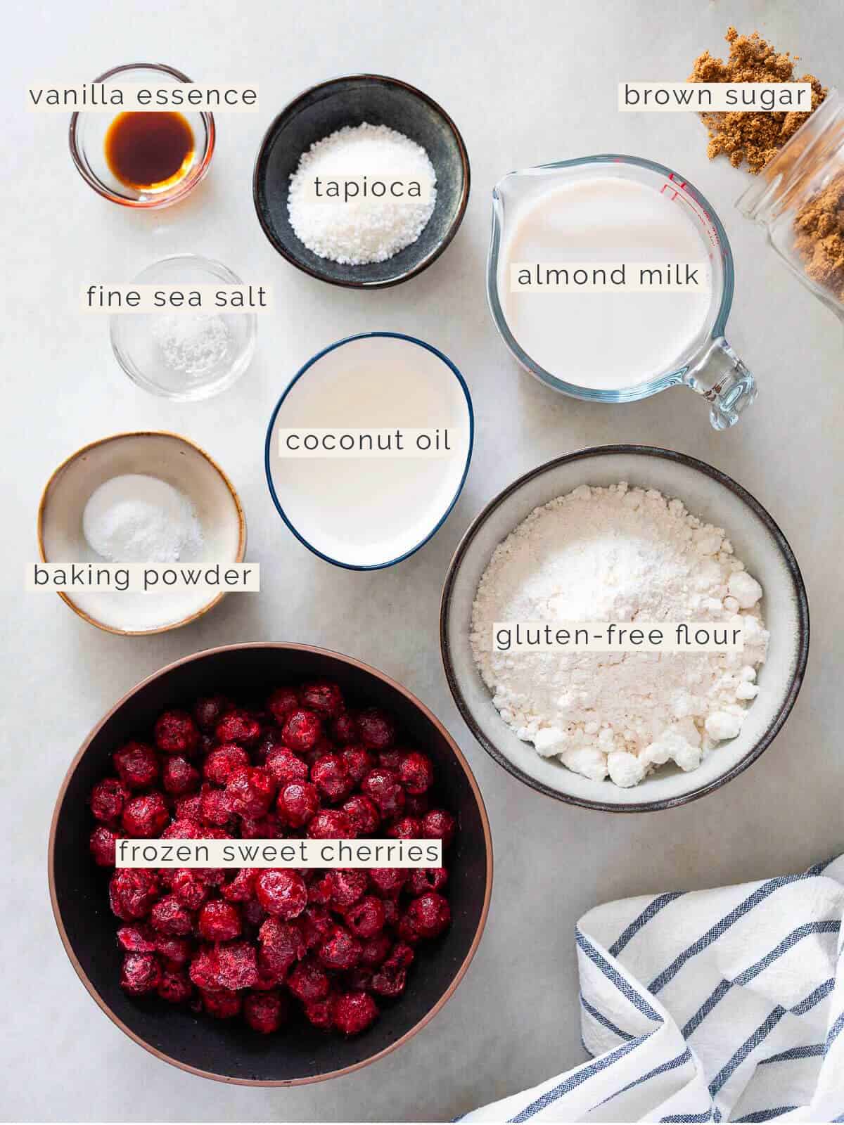 Ingredients for Vegan Sherry Pie - Various ingredients labeled: tapioca, almond milk, coconut oil, fine sea salt, baking powder, gluten-free flour, and frozen cherries.