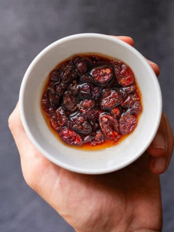 small bowl with dried cranberries soaking in vermouth.