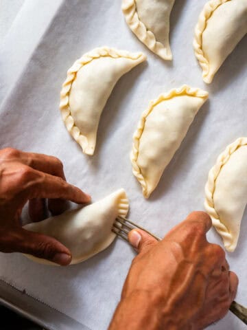 closing empanadas with a fork.