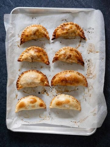 baked apple empanadas on a sheet pan.