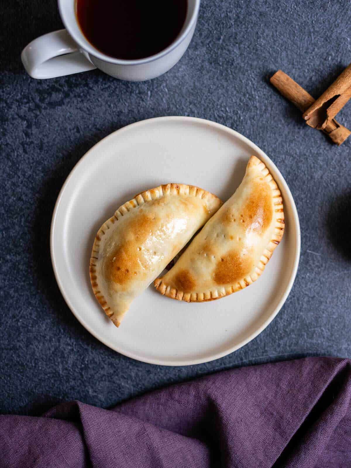 plate with two baked apple empanadas.