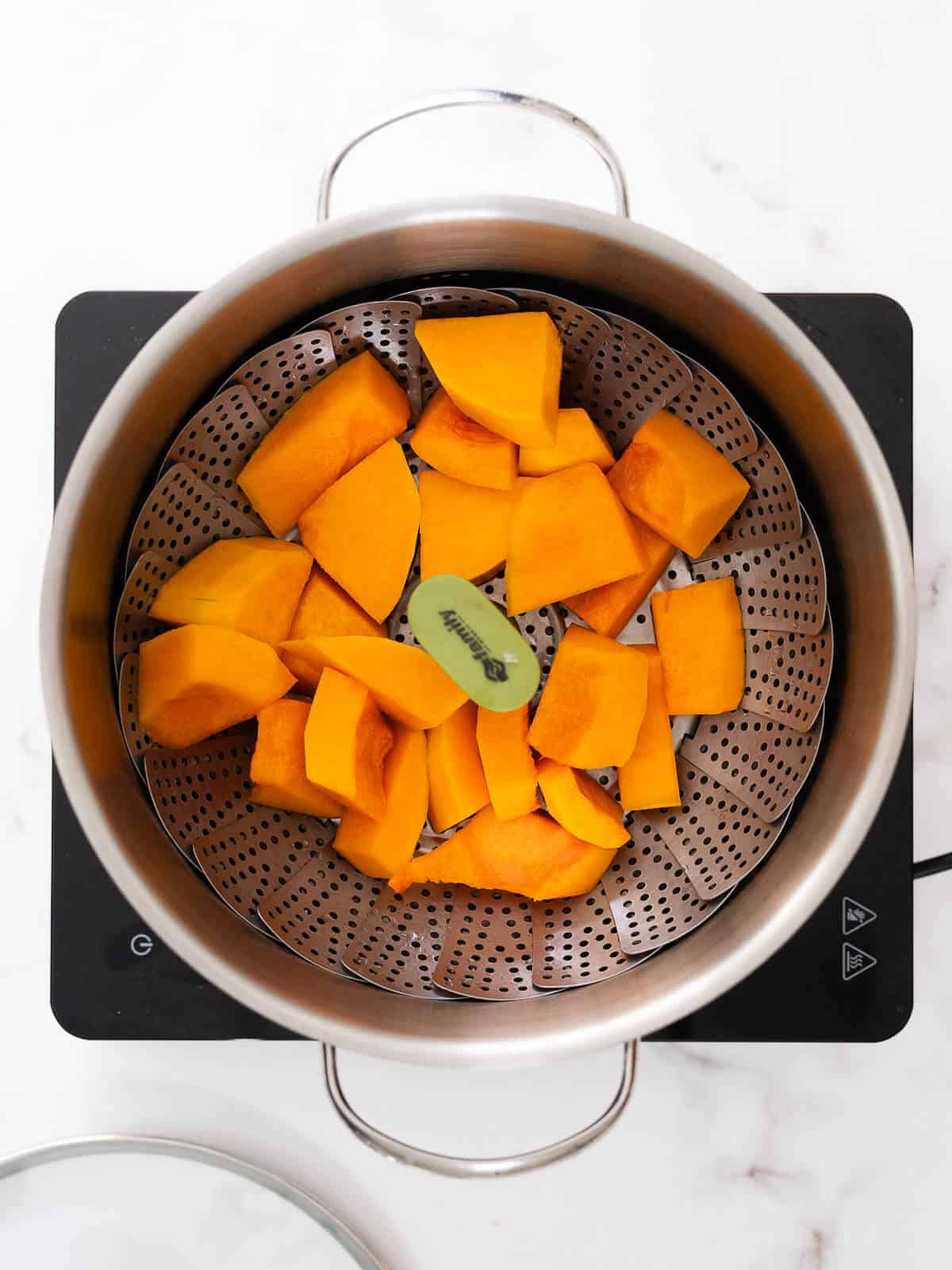 cubed pumpkin in a steamer basket.