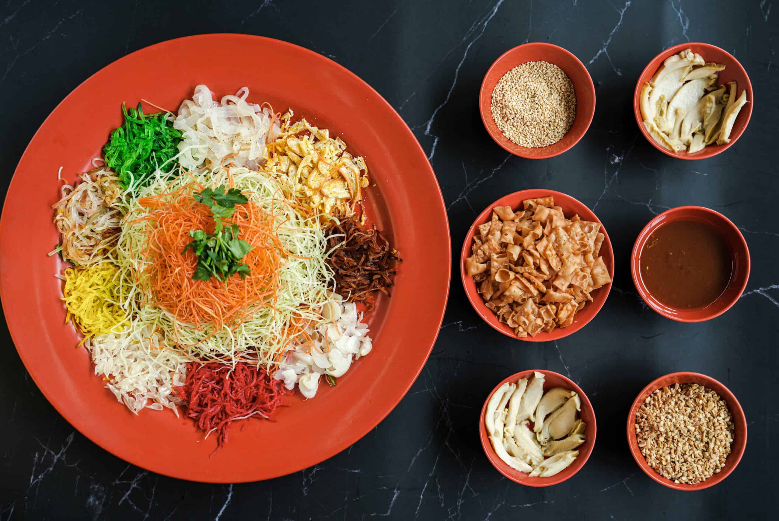 aerial shot of ingredients and an assembled salad dish commonly eaten during Chinese New Year gatherings called, 