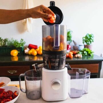 adding tomato into blender to make this recipe